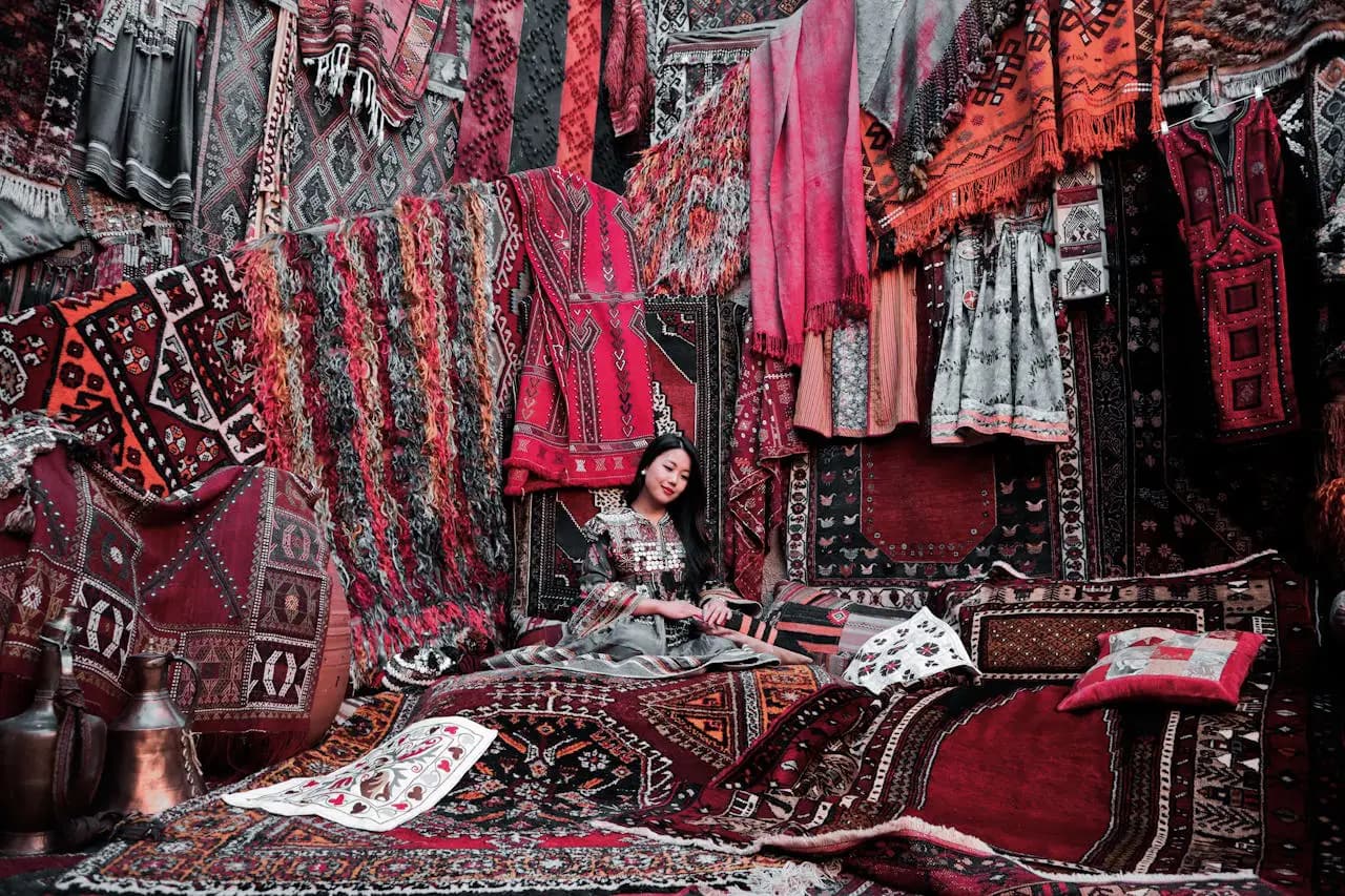 Woman Sitting on a Carpet, with carpets and other textiles all around her in Turkey